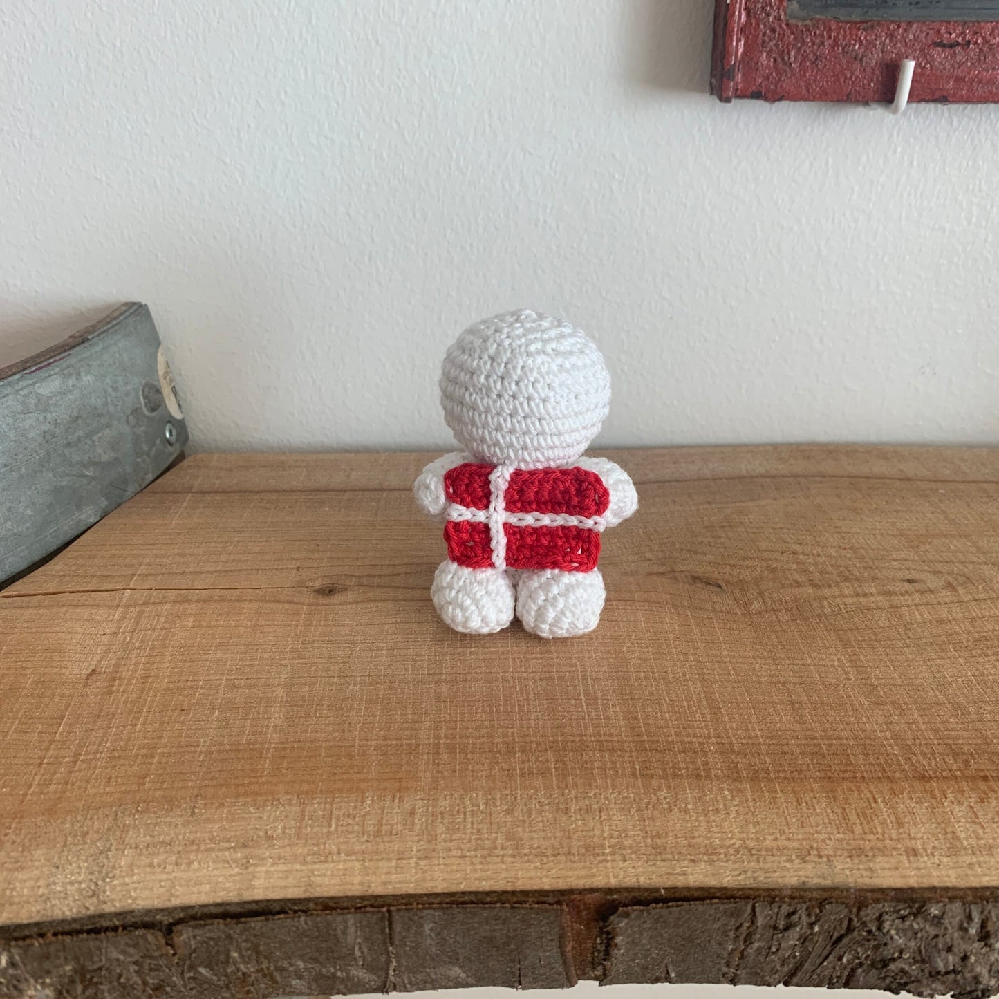 Hæklet dansk roligan-figur med rødt Danmark-bånd set bagfra
